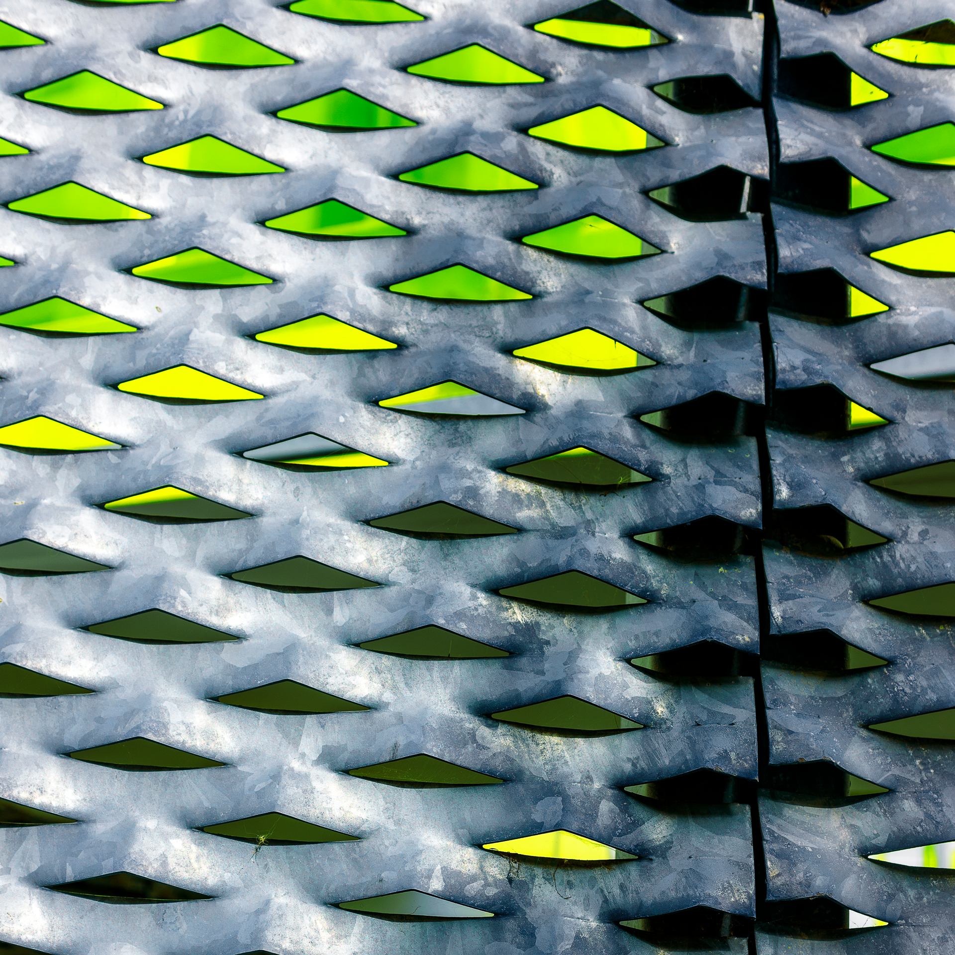 Nuances de jaune à travers une tôle galvanisée perforée